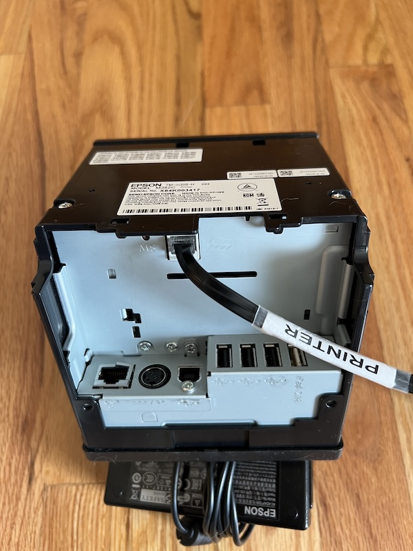 The printer cable connected to the back of the Epson TM Printer