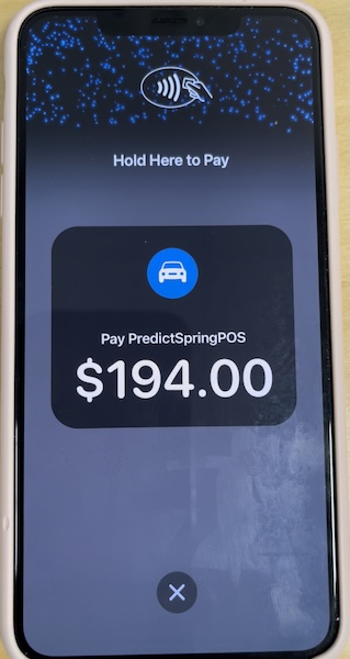 An iPhone prompting a card holder to tap the iPhone to pay.